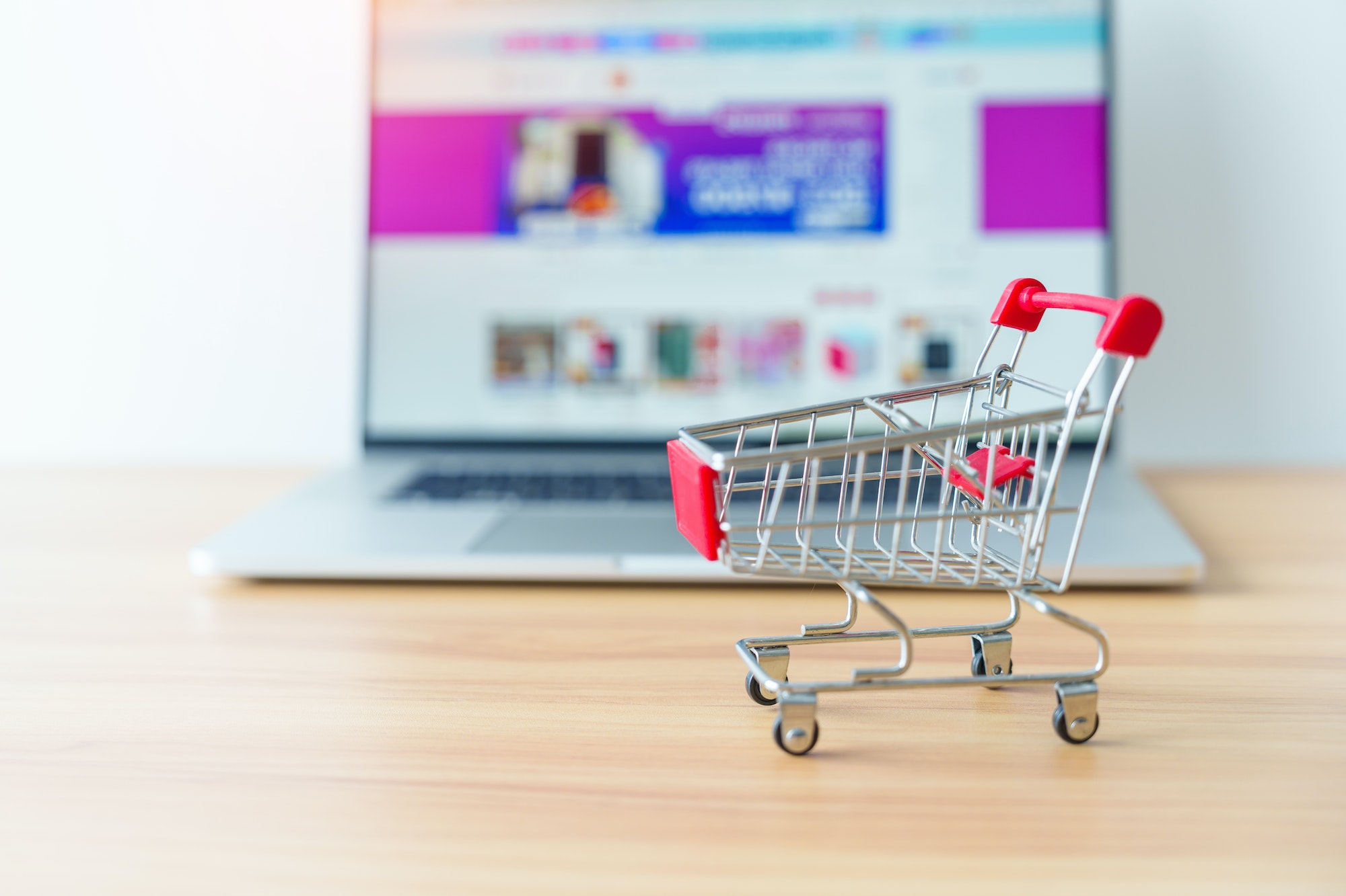 Shopping cart and laptop computer with marketplace website.